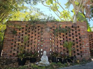 Brick wall with Buddha and plants, in Florida 
